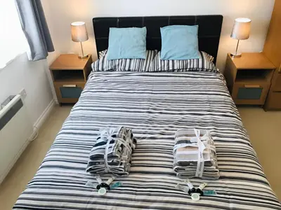 a bedroom with a bed with towels on it at Spacious 2-Bed Flat in Homerton House in Cambridge