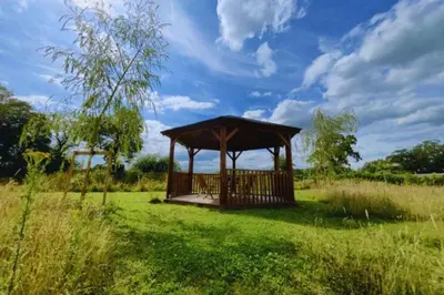 a wooden gazebo in a field of grass at Bears House in Westley Waterless