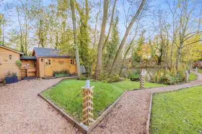 a backyard with a log cabin and a garden at Bears House in Westley Waterless