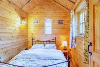 a bedroom with a bed in a log cabin at Bears House in Westley Waterless