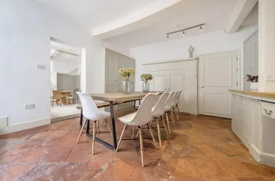a kitchen with a wooden table and white chairs at 6 Angel Hill, Bury st Edmunds in Bury Saint Edmunds