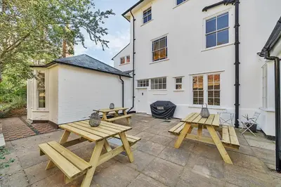 two picnic tables on a patio in front of a building at 6 Angel Hill, Bury st Edmunds in Bury Saint Edmunds