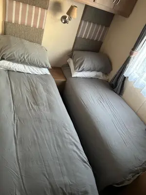 two beds sitting next to each other in a room at 2 Bedroom caravan in Saint Osyth