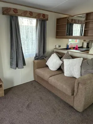 a living room with a couch and a window at 2 Bedroom caravan in Saint Osyth