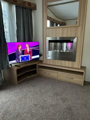 a flat screen tv sitting in a entertainment center at 2 Bedroom caravan in Saint Osyth