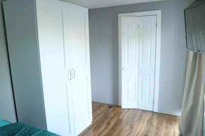 an empty room with white cabinets and a door at Galleywood House in Great Baddow