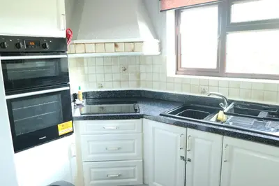 a kitchen with a sink and a stove top oven at Galleywood House in Great Baddow