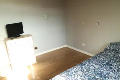 a bedroom with a bed and a tv on a dresser at Galleywood House in Great Baddow
