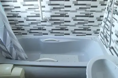 a white bath tub in a bathroom with a toilet at Galleywood House in Great Baddow