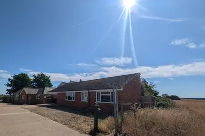 a brick house with the sun in the sky at Grapnells Lodge, Wallasea Island, Rochford, Essex in Rochford