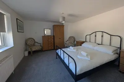 a bedroom with a large bed and a dresser at Grapnells Lodge, Wallasea Island, Rochford, Essex in Rochford