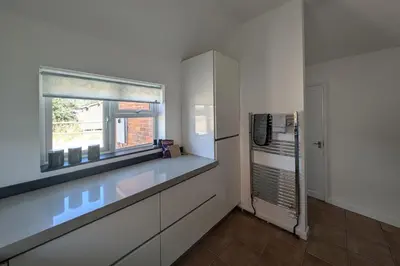 a white kitchen with a window and a sink at Grapnells Lodge, Wallasea Island, Rochford, Essex in Rochford