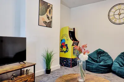 a living room with a tv and a vase on a table at 3 Bedroom Property, Free Parking for 3 Vehicles in Mile End