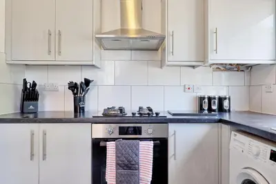 a kitchen with white cabinets and a stove at 3 Bedroom Property, Free Parking for 3 Vehicles in Mile End