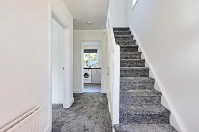 a staircase in a home with white walls and white floors at 3 Bedroom Property, Free Parking for 3 Vehicles in Mile End