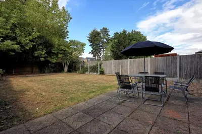 a table and chairs with an umbrella in a yard at 3 Bedroom Property, Free Parking for 3 Vehicles in Mile End