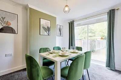 a dining room with a table and green chairs at 3 Bedroom Property, Free Parking for 3 Vehicles in Mile End