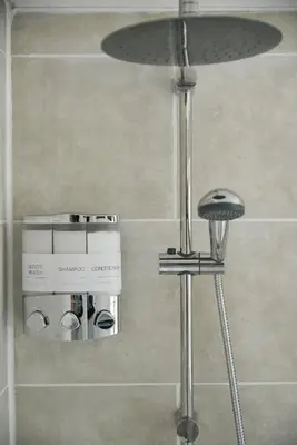 a bathroom with a shower with a stool in it at Cosy Luxe 3Bed Retreat Hot Tub BBQ Parking Near Town Perfect for Contractors Families Short & Long Stay in Hythe