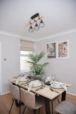 a dining room table with chairs and a dining room at Cosy Luxe 3Bed Retreat Hot Tub BBQ Parking Near Town Perfect for Contractors Families Short & Long Stay in Hythe