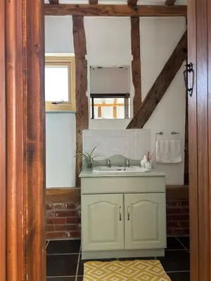 a bathroom with a sink and a mirror at Heritage Cottage with a Pool in Diss