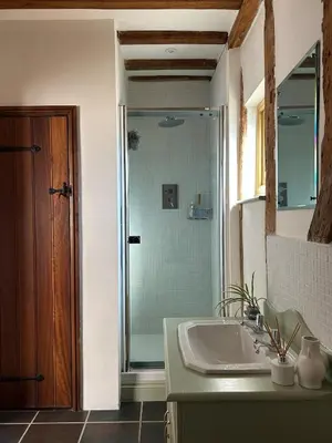a bathroom with a sink and a glass shower at Heritage Cottage with a Pool in Diss