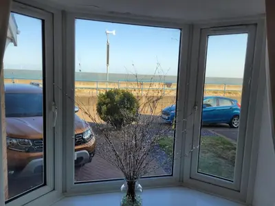 a window with a view of a parking lot at Seaview house - Three bedroom house with close access to beach by Catchpole Stays in Clacton-on-Sea