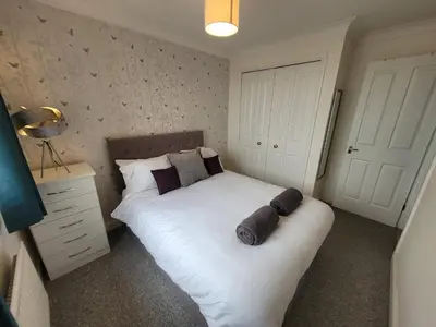 a bedroom with a large white bed with pillows at Seaview house - Three bedroom house with close access to beach by Catchpole Stays in Clacton-on-Sea