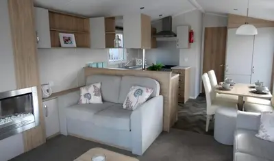a living room and kitchen with a couch and a table at Lovely Caravan At Carlton Meres Holiday Park Ref 60034O in Saxmundham