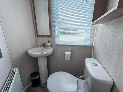 a small bathroom with a toilet and a sink at Cosy 8 Berth Caravan With Decking And Lake-Views At Weeley Bridge Ref 69001Lv in Clacton-on-Sea