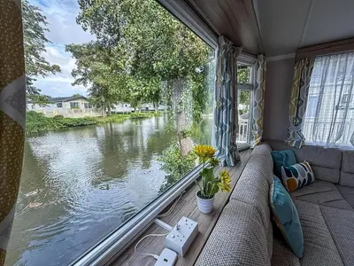 a view of a river from a window in a caravan at Cosy 8 Berth Caravan With Decking And Lake-Views At Weeley Bridge Ref 69001Lv in Clacton-on-Sea