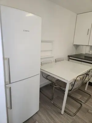 a kitchen with a table and a refrigerator at Beautiful two Bedroom house Entire house in Stevenage
