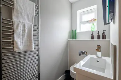 a white bathroom with a sink and a mirror at Modern Central Studio With Parking in Cambridge