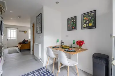 a kitchen and living room with a table and chairs at Modern Central Studio With Parking in Cambridge
