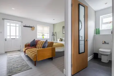 a living room with a couch and a bed at Modern Central Studio With Parking in Cambridge