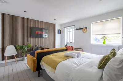 a bedroom with a bed and a couch at Modern Central Studio With Parking in Cambridge