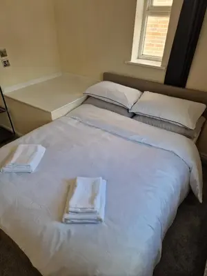 a large white bed with towels on top of it at SK Short Let