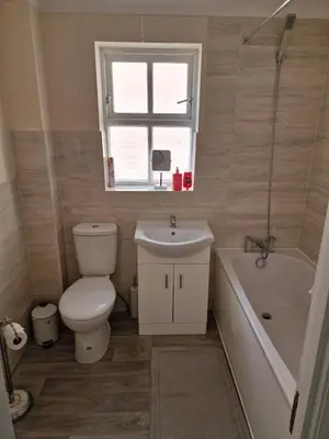 a bathroom with a toilet and a sink and a tub at SK Short Let
