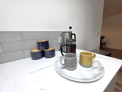 a counter with three coffee cups on a plate at Deluxe One Bed Flat at Dawe Luxury Suites - An Entire Apartment near Ely Cathedral & Train Station - Ideal Gateway to Explore Ely, Cambridge, Norfolk & London - Sleeps up to 4 in Ely