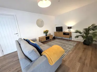 a living room with a couch and a tv at Deluxe One Bed Flat at Dawe Luxury Suites - An Entire Apartment near Ely Cathedral & Train Station - Ideal Gateway to Explore Ely, Cambridge, Norfolk & London - Sleeps up to 4 in Ely