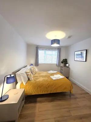 a bedroom with a bed with a yellow bedspread at Stunning One Bed Flat at Dawe Luxury Suites - An Entire Apartment near Ely Cathedral & Train Station - The Perfect Base to Explore Ely, Cambridge, Norfolk & London - 2 Guests Max in Ely