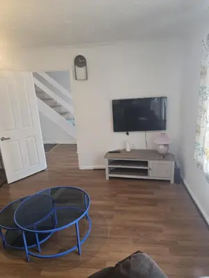 a living room with a tv and a blue table at Homely three bedroom in Vange