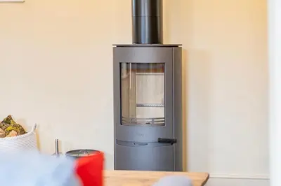 a stove in a kitchen with a wooden table at Coach House with Hot Tub in Idyllic Bury St Edmunds in Newton