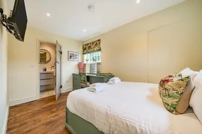 a bedroom with a large white bed in a room at Coach House with Hot Tub in Idyllic Bury St Edmunds in Newton