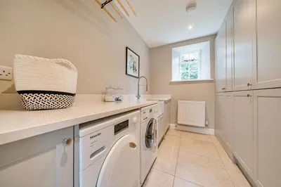 a white laundry room with a washer and dryer at Coach House with Hot Tub in Idyllic Bury St Edmunds in Newton