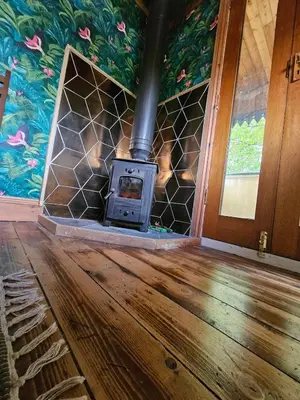a wood burning stove in a room with a floor at offgrid showmans caravan in Kelvedon Hatch
