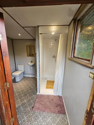 a small bathroom with a toilet and a shower at offgrid showmans caravan in Kelvedon Hatch