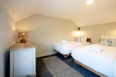 a room with two beds and a table with a lamp at Rose Cottage, Blaxhall - Near Snape Maltings, Orford, Thorpeness & Aldeburgh - Aldeburgh Coastal Cottages in Blaxhall
