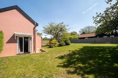 an empty yard next to a pink house at Rose Cottage, Blaxhall - Near Snape Maltings, Orford, Thorpeness & Aldeburgh - Aldeburgh Coastal Cottages in Blaxhall