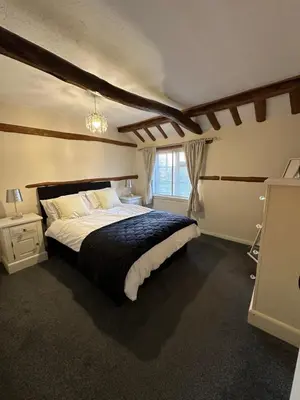 a bedroom with a large bed and a window at Rosemary cottage in Mountnessing