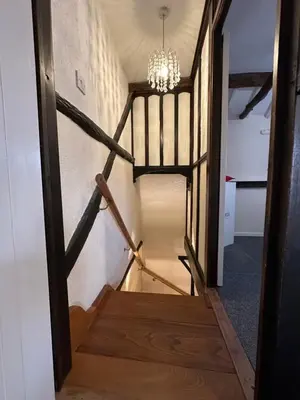 a staircase with a chandelier in a room at Rosemary cottage in Mountnessing